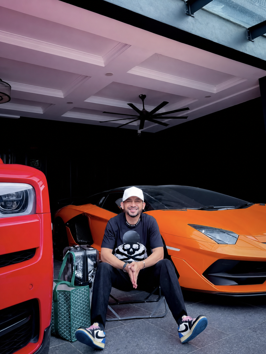 El Azman duduk bersama kereta berwarna merah dan oren